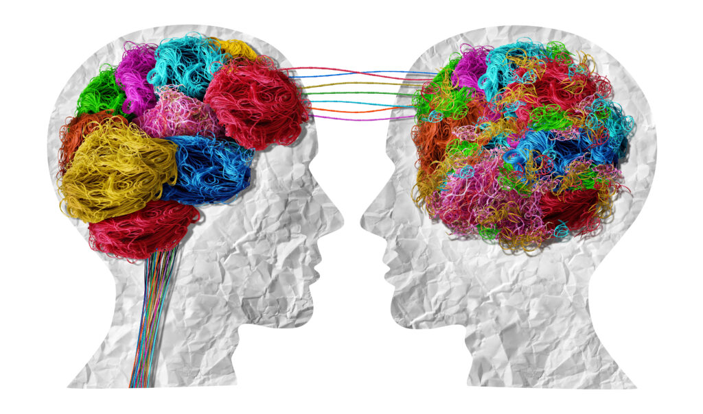 „Illustration zweier einander zugewandter Köpfe, deren Gehirne aus farbigen Fäden bestehen, die miteinander verbunden sind und den Austausch von Gedanken sowie emotionalen Prozessen symbolisieren. Das Bild steht sinnbildlich für Kommunikation, mentale Gesundheit und therapeutische Arbeit – und wird häufig im Kontext von Psychotherapie München, Psychotherapeut München und Psychotherapie in der Nähe verwendet.“